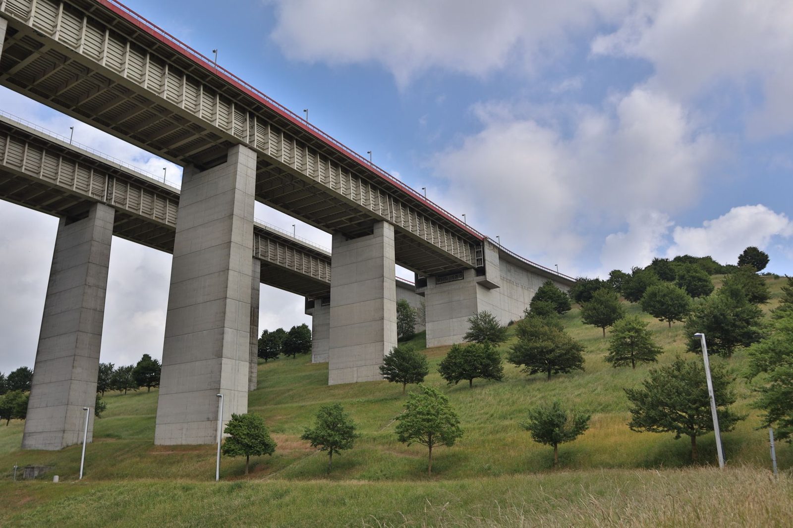 A concrete rail viaduct crossing green farmland