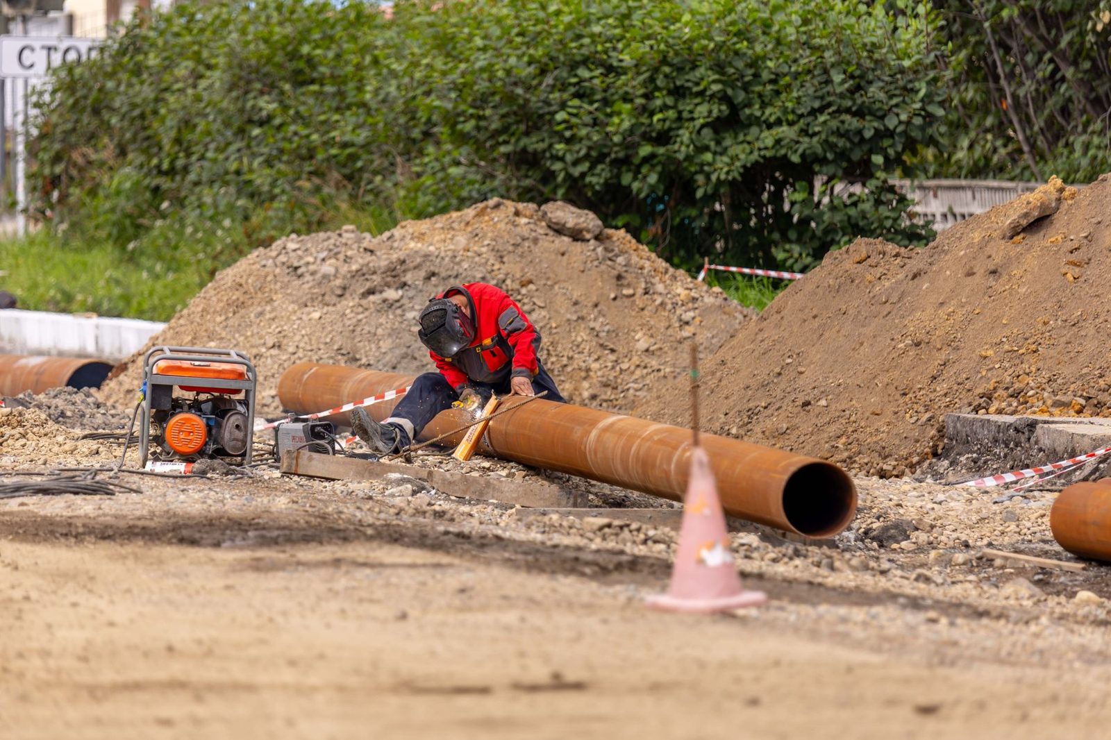 A worker laying pipe in a trench