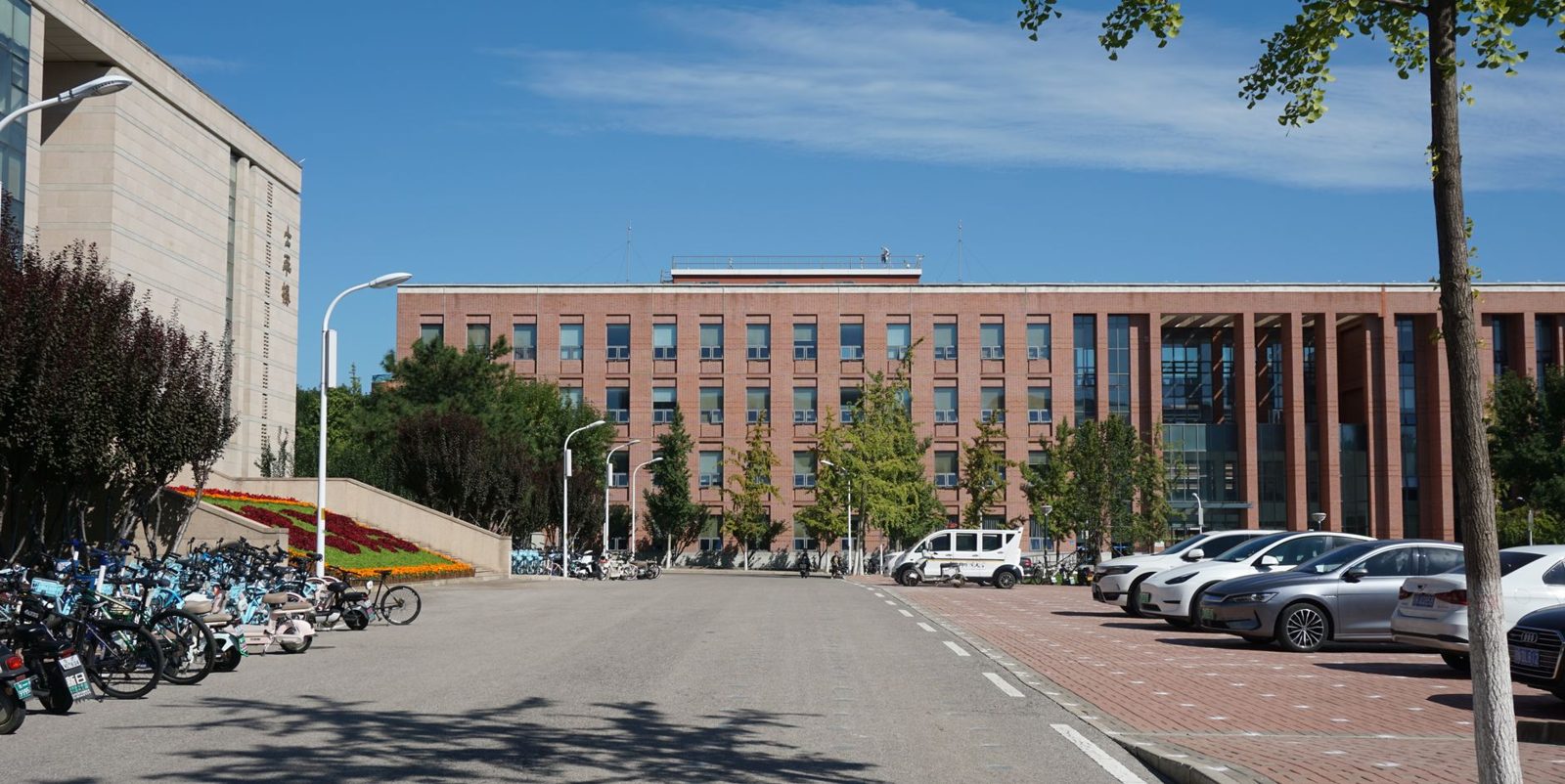 A brick office building with a parking lot out front