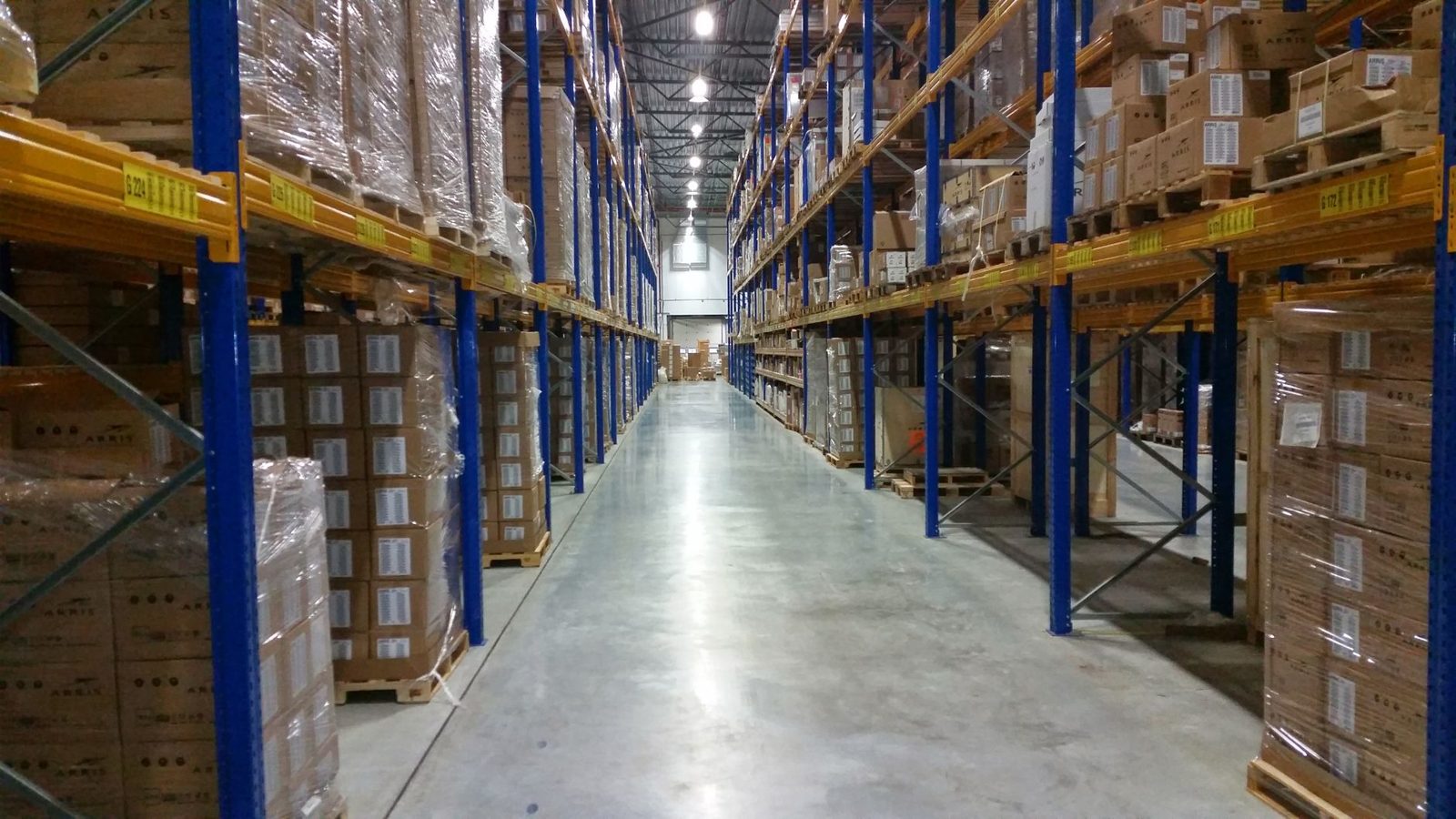 A long warehouse aisle with stacked pallets