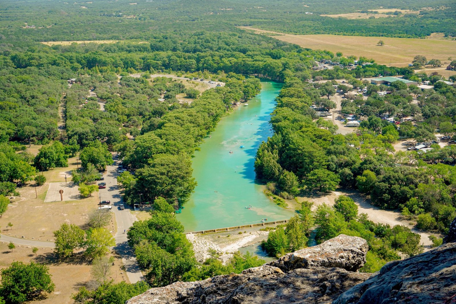 A clear green river winding through Hill Country towns