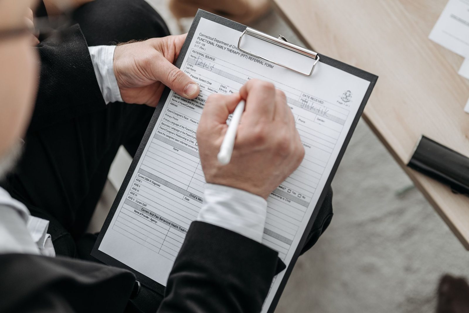 A person signing a service agreement on a clipboard
