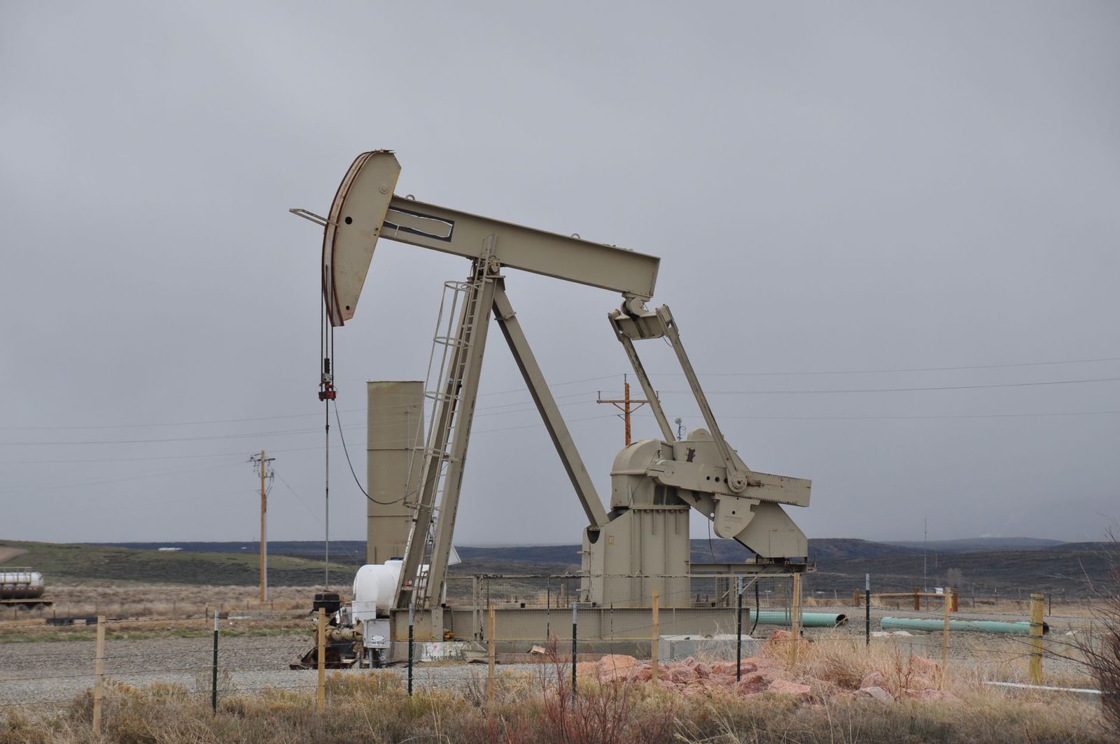 An oil pumpjack on open ground in an energy field
