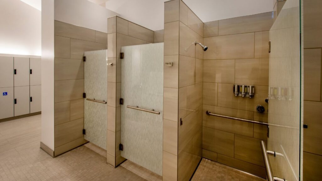 Clean tiled private shower stalls with grab bars, the finish standard our trailer suites match