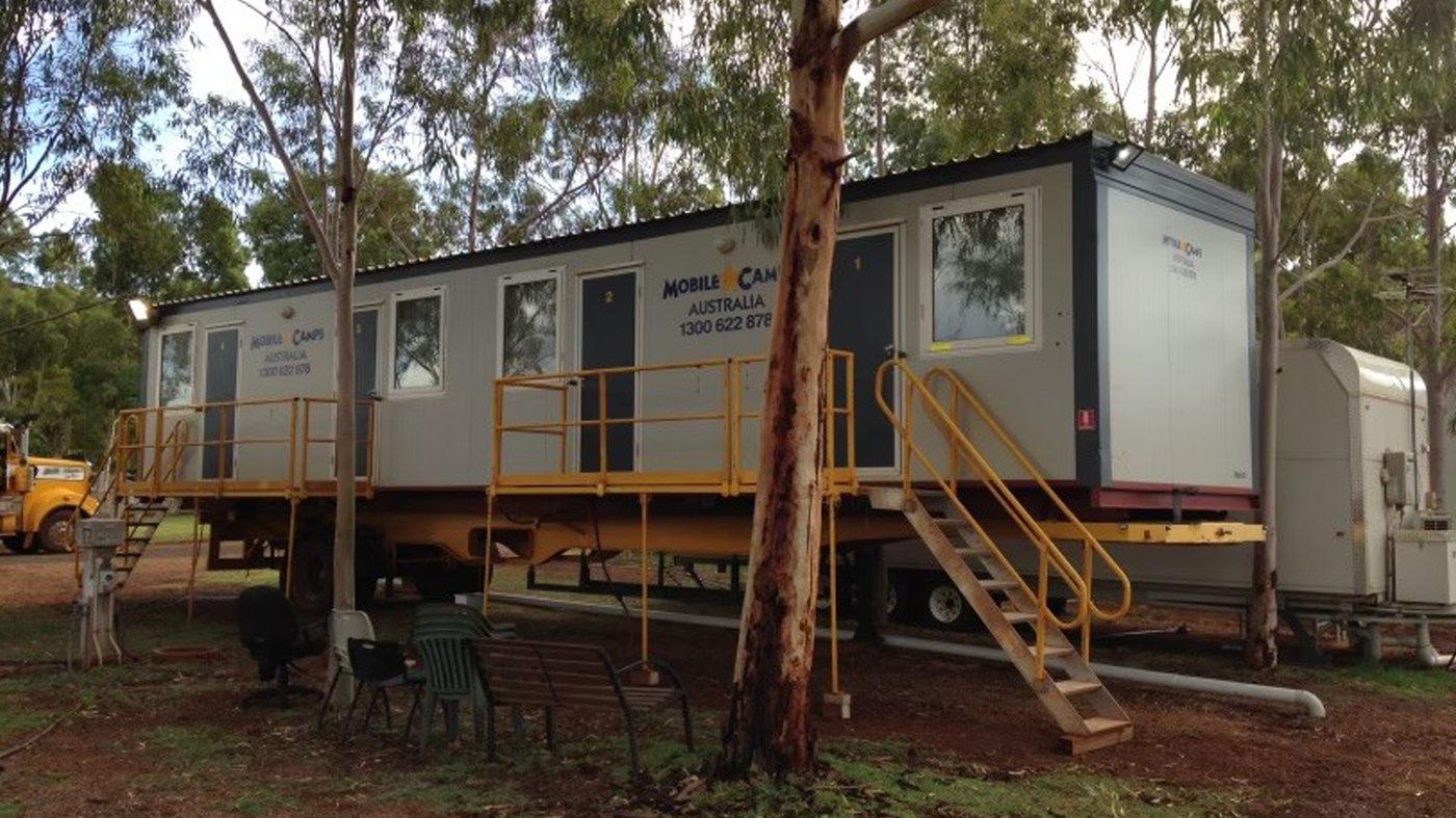 Combination trailer positioned at a remote work site with utility access staged
