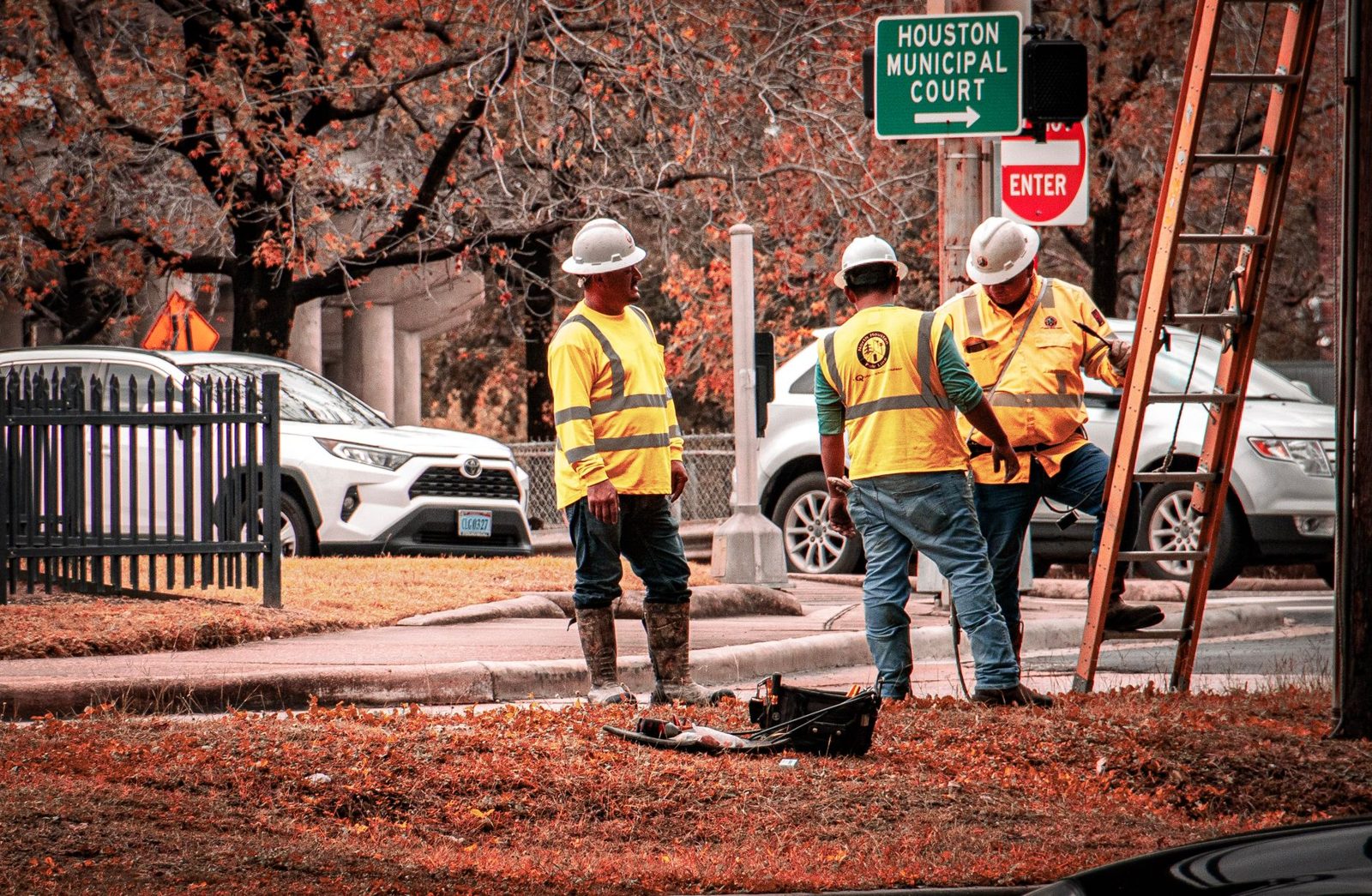 A road crew in safety vests working a street job in the heat