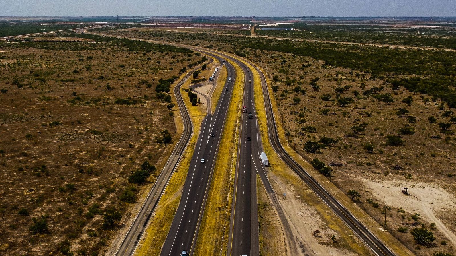A divided highway cutting across open Texas country