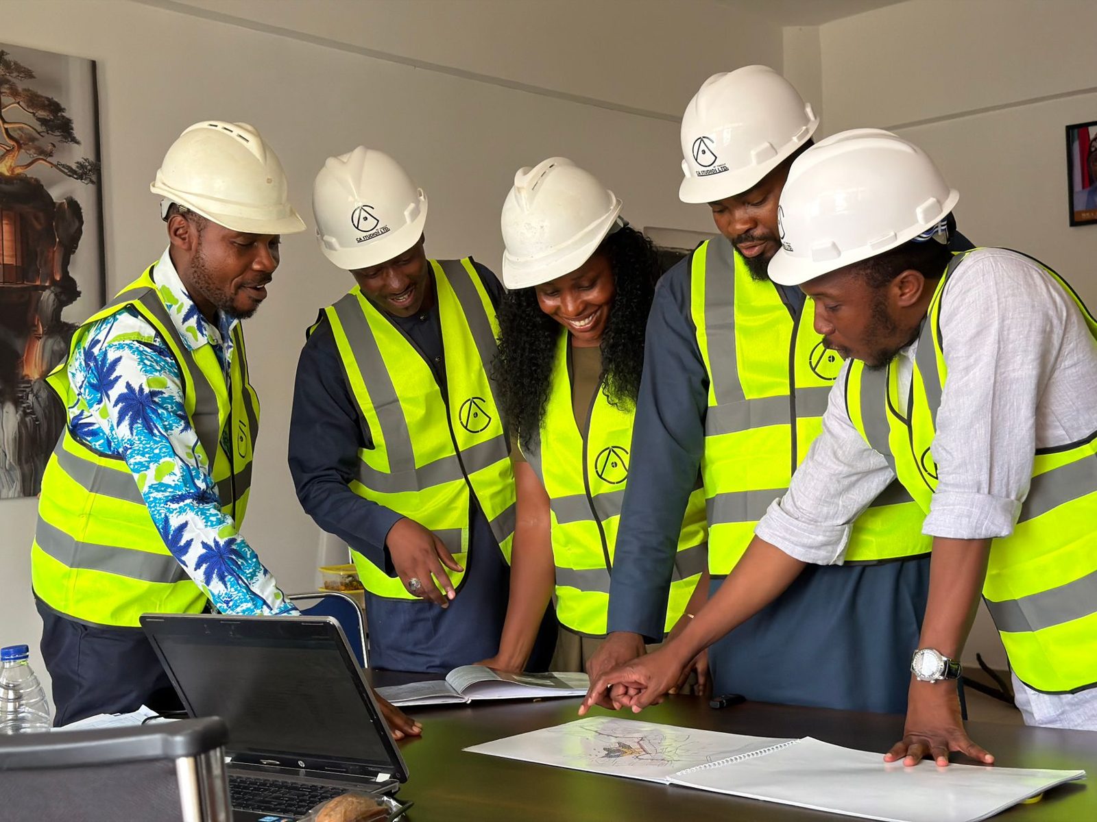 A crew in hard hats reviewing a site plan together